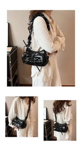 Detail of black glossy underarm bag featuring bow tie and pleated cloud shoulder strap