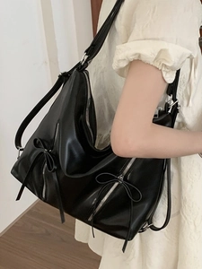 Minimalist black soft leather tote bag with stylish bow and silver zipper detail
