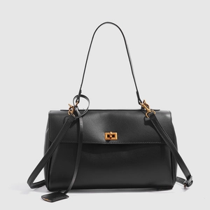 Détail du sac cabas en cuir noir avec fermoir rotatif doré et texture lisse élégante
