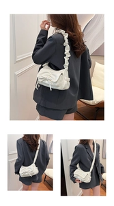 Detail of white pleated cloud bag with delicate drawstring bow and soft PU leather texture