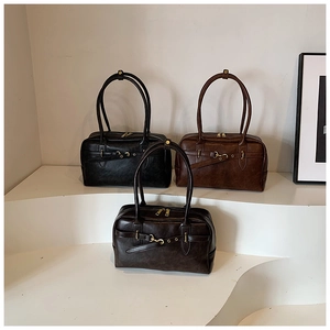 Trois sacs Boston vintage en noir, marron foncé et café sur des marches blanches