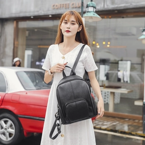 Fashionable black faux leather backpack for women with a minimalist round front zipper pocket