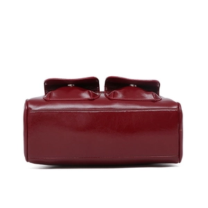 Detailed view of the bottom and side pockets of this burgundy oil-wax leather bowling bag