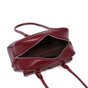 Top view of deep red oil wax leather handbag showing silver zipper and internal lining