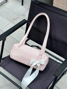 Close-up of pink bow shoulder bag with white satin detail on a camping chair