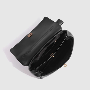 Intérieur détaillé du cabas en cuir noir montrant le compartiment et la poche zippée