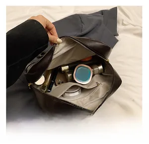 Vue de dessus montrant l'intérieur spacieux de ce sac vintage en cuir marron avec maquillage