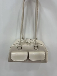Detail of cream oil wax leather shoulder bag with dual front pockets and glossy finish