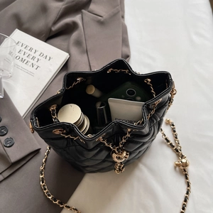 Close-up of black quilted bucket bag interior showing capacity for makeup and phone