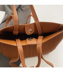 Close-up of brown litchi grain tote bag with contrast stitching and silver magnetic clasp