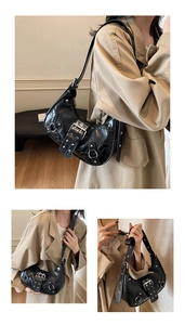 Chic black crocodile pattern crescent shoulder bag with metal buckles and rivets for women.