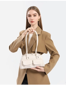 Close-up detail of cream white faux leather shoulder bag with front flap pockets