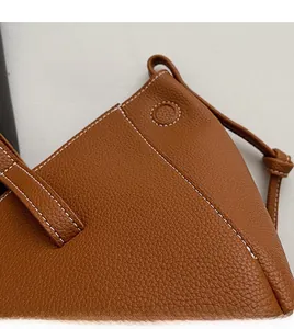 Detail of caramel leather tote with white handmade stitching and lychee grain texture