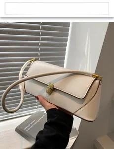 Detailed view of white leather shoulder bag featuring vintage gold clasp and brown oil edges