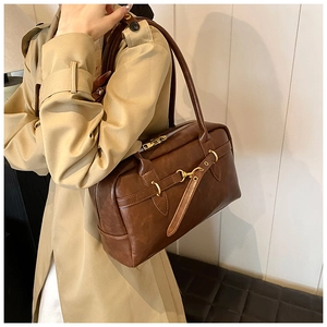 Détail du sac Boston marron café vintage avec boucle mors dorée et texture cuir
