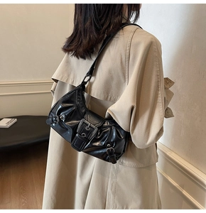 Detail of black pleated leather crossbody bag with vintage buckle and adjustable strap