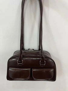 Detail view of dark brown faux leather bowling bag with silver zippers and double pockets