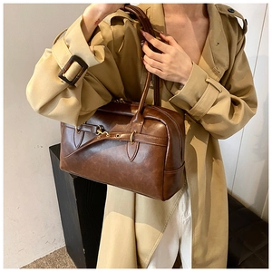 Détail du sac Boston en cuir vintage marron foncé avec boucle en métal et poignées