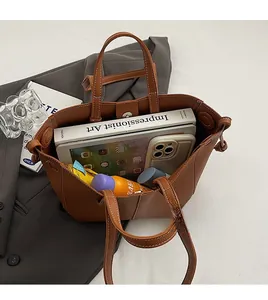 Top view of brown leather tote bag interior showing large capacity for iPad and daily items