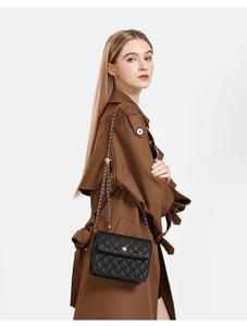 Détail du sac matelassé noir avec fermoir fleur dorée et bandoulière en chaîne