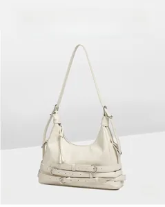 Détail du sac à bandoulière en cuir synthétique crème avec texture et boucles décoratives