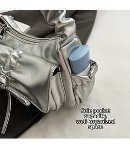 Detail of silver pleated bag side pocket showing functional storage and internal layout