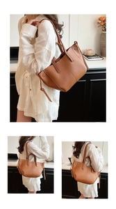 Detail of a brown lychee-grain leather tote bag featuring drawstring accents and dual handles