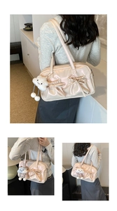 Detail of glossy champagne tote bag with bow accents and fluffy cloud pendant charm