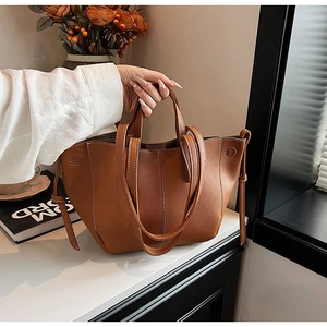 Detail of caramel leather tote bag with lychee texture and adjustable shoulder strap