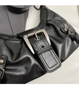 Détail du sac à épaule plissé noir avec boucle métallique et surpiqûres de style vintage