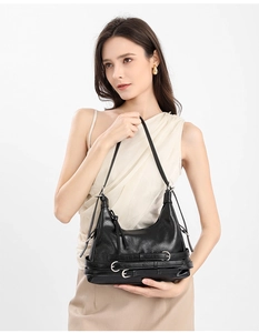 Détail du sac à bandoulière en cuir noir avec trois boucles de ceinture décoratives au bas