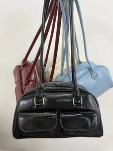 Close-up of vintage faux leather bowling bags in black, burgundy, white and blue colors