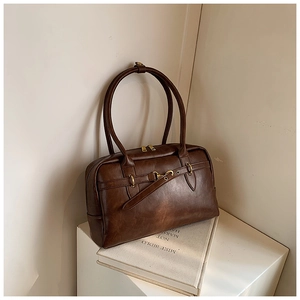 Vue détaillée du sac bandoulière vintage en cuir marron foncé avec fermetures dorées