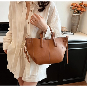 Brown leather tote bag with contrast stitching and drawstring detail for daily commute
