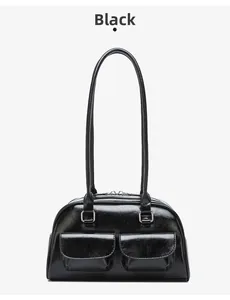 Close-up of a glossy black bowling bag featuring symmetrical front pockets and silver hardware