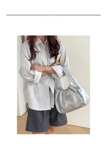 Silver metallic pleated cloud bag worn by model as a stylish shoulder underarm hobo bag