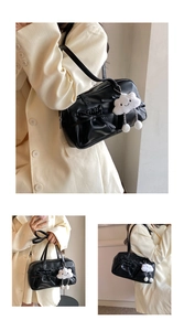 Detail showing black bow tote bag with plush cloud charm in multiple carrying styles