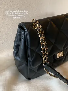 Close-up of quilted leather texture and gold metal chain strap on a black shoulder bag