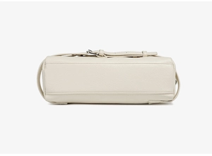 Vue détaillée du dessous du sac en cuir blanc crème avec coutures fines et texture