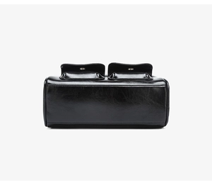 Detail view of the black oiled leather shoulder bag featuring side flap pockets and fine stitching