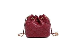 Detail of burgundy quilted leather bucket bag with gold chain strap and drawstring closure