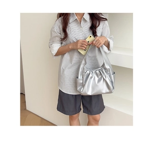 Close-up of silver pleated croissant bag showing metallic texture and side pocket detail