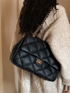 Detailed close-up of quilted black leather texture and golden metal chain strap