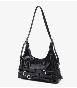 Détail du sac à bandoulière vintage noir brillant avec boucles décoratives argentées