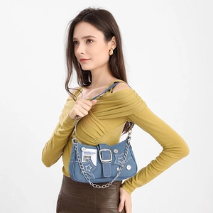 Detail of blue denim star shoulder bag with silver chain and vintage button accents