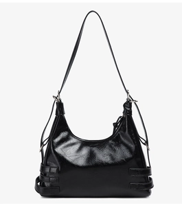 Détail du sac hobo noir brillant avec boucles argentées et texture en cuir froissé
