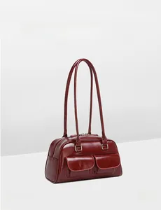Close-up of glossy oil-wax leather texture and silver zipper detail on burgundy bag