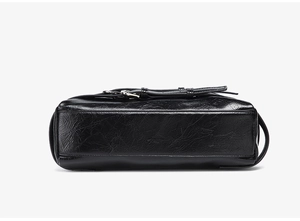 Vue détaillée du fond du sac noir avec texture huilée plissée et boucle métallique