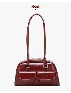 Detail of red oil-wax leather shoulder bag featuring dual front flap pockets and glossy finish