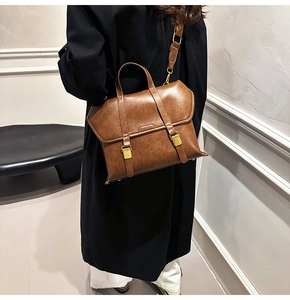 Detailed view of vintage brown faux leather handbag with metal buckle straps on back of model